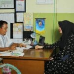 Nauczyciel i rodzic rozmawiają w szkolnym biurze w Indonezji