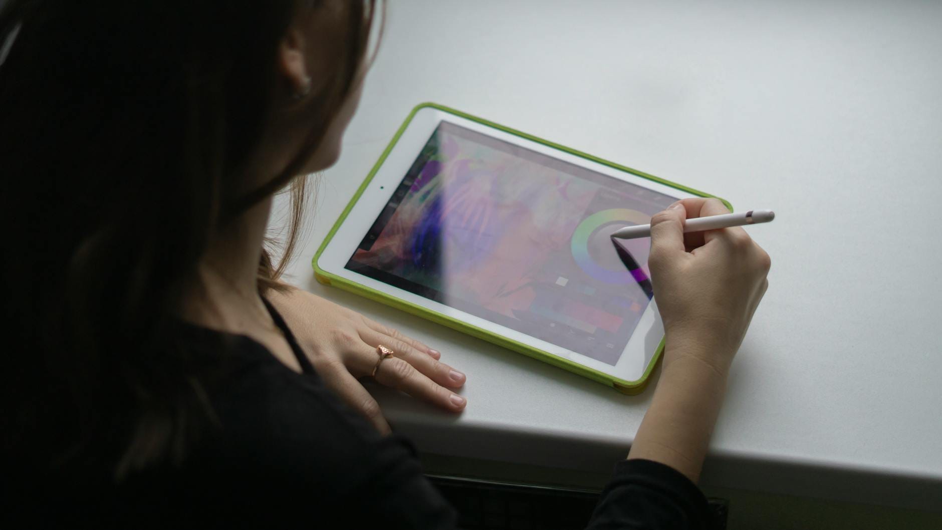 Nauczycielka rysuje rysikiem na tablecie, tworząc cyfrową grafikę