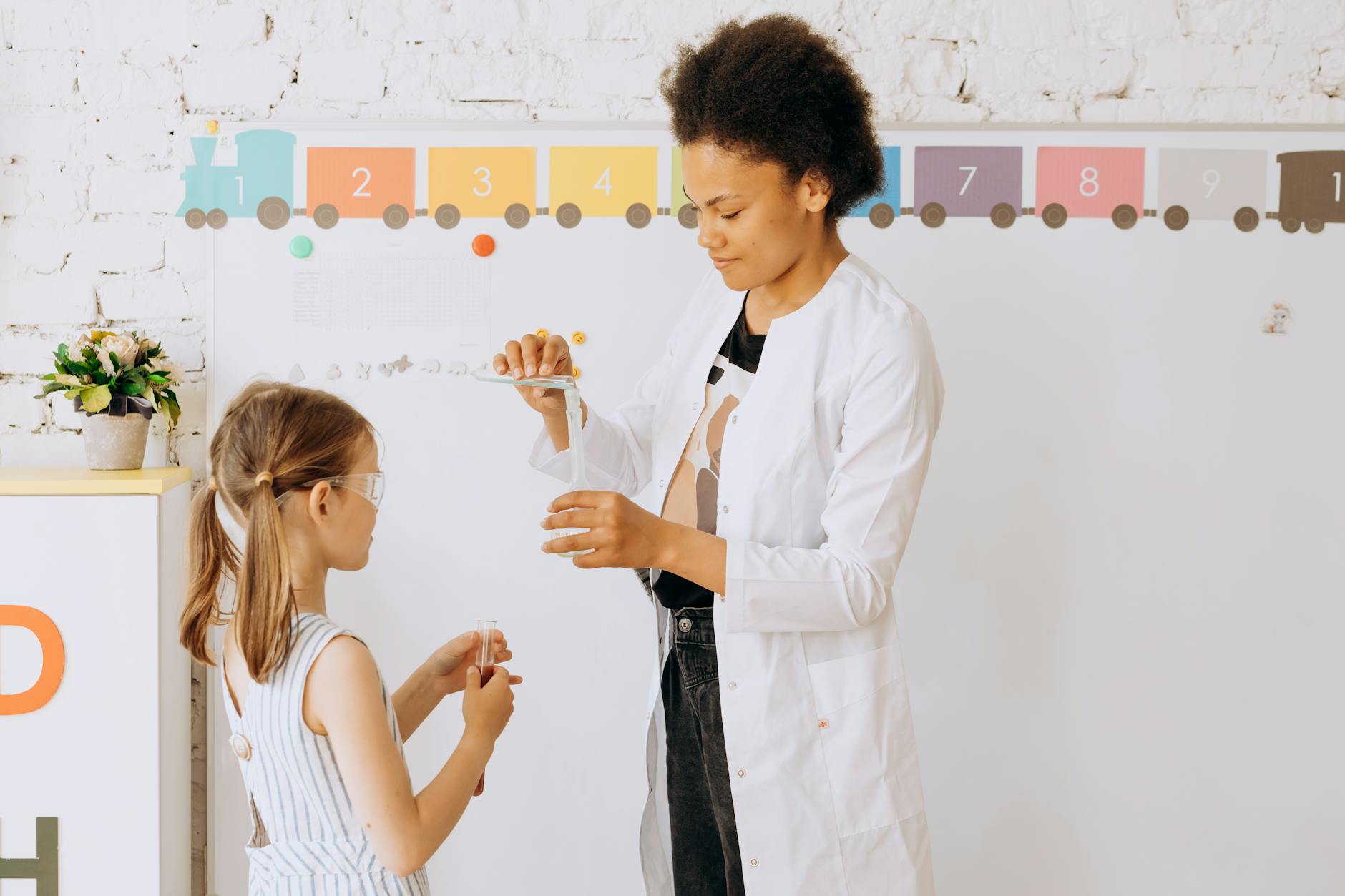 Nauczyciel pomaga uczniowi w doświadczeniu z nauk przyrodniczych