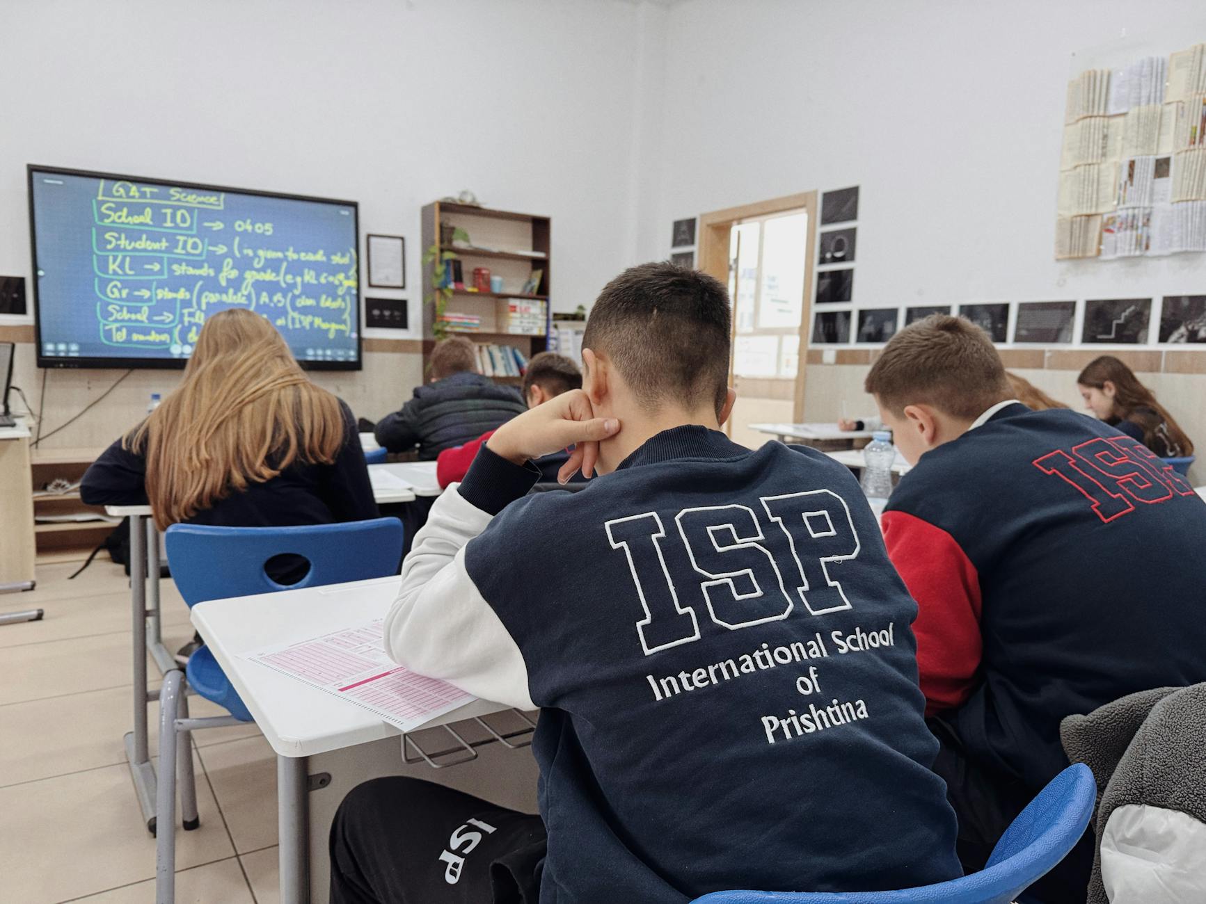Uczniowie słuchają nauczyciela w międzynarodowej klasie szkolnej